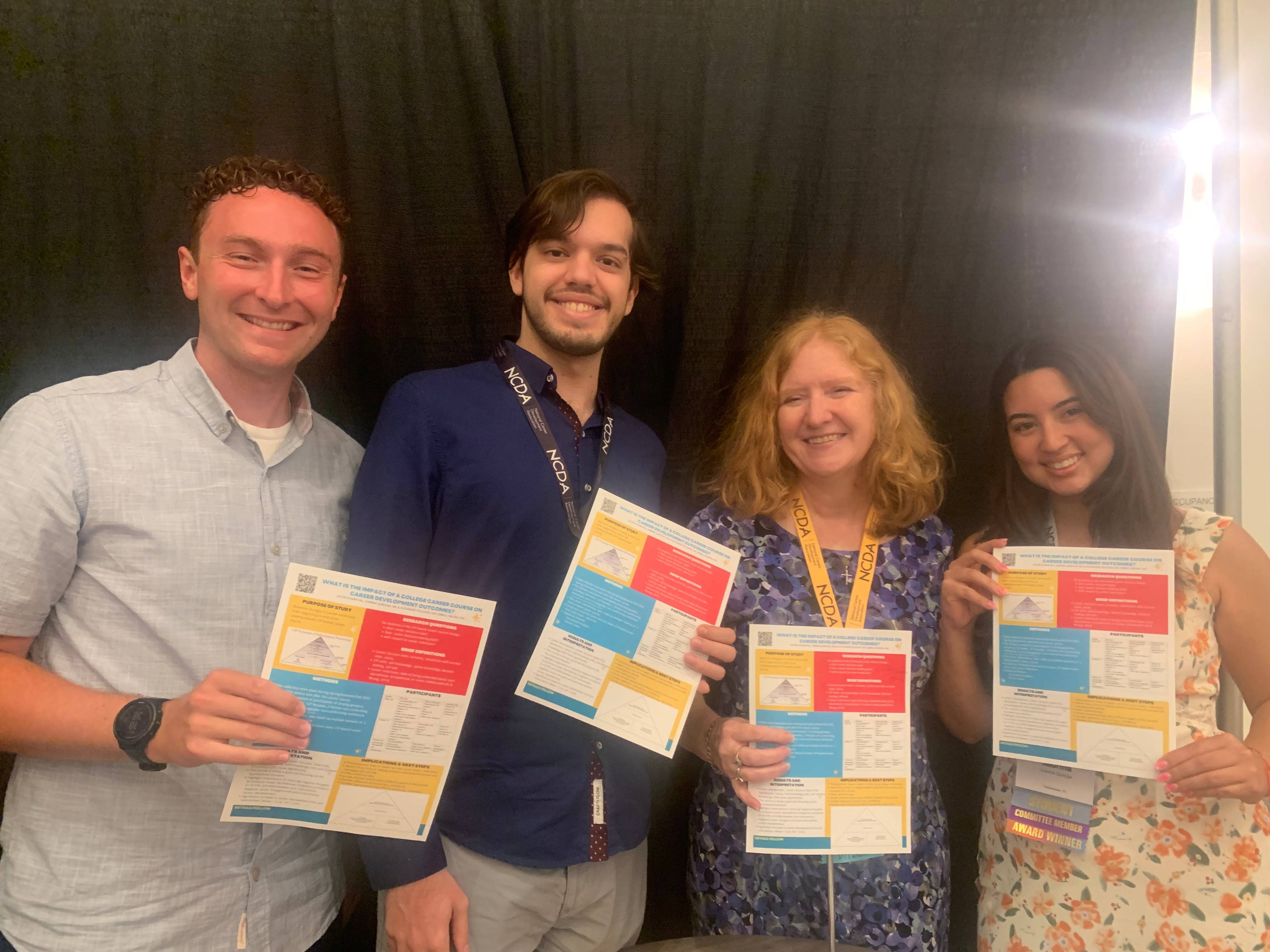 four people showing papers