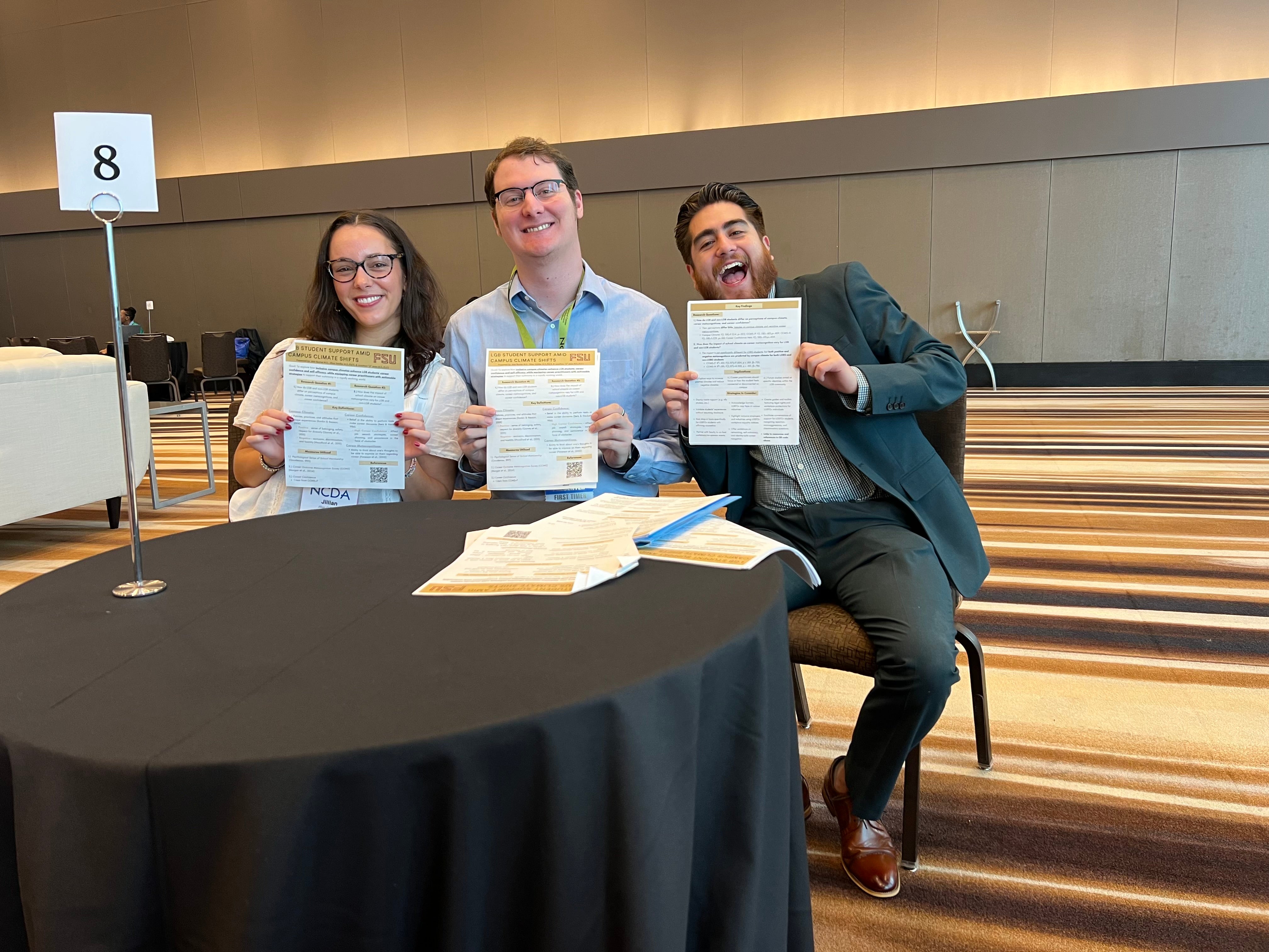 three people showing papers
