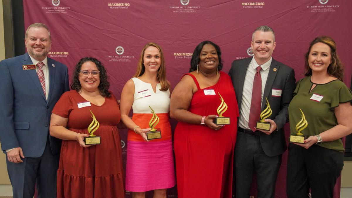 Torch Award recipients lined up with their awards along side Dean Damon Andrew