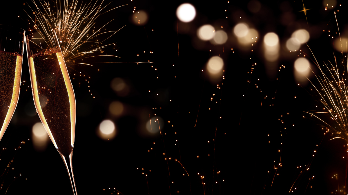 A black and gold New Year's Eve scene with glasses of champagne and fireworks