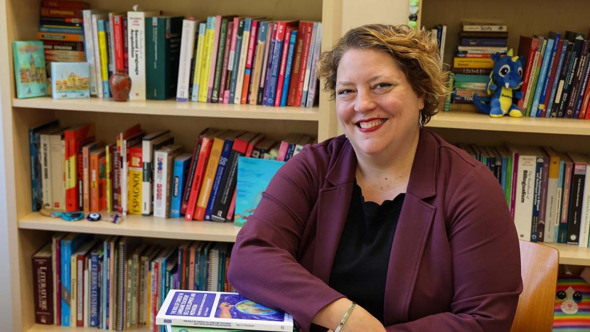 Amy Thompson sitting near a bookshelf