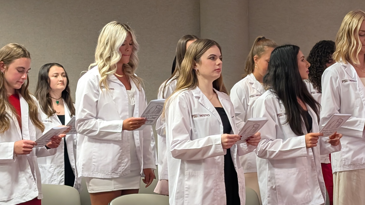 students read an oath after receiving their white coats
