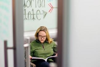 student reading a book in a study room